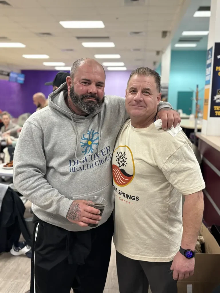 Two men with arms around each other at the Nashoba Springs bowling outing