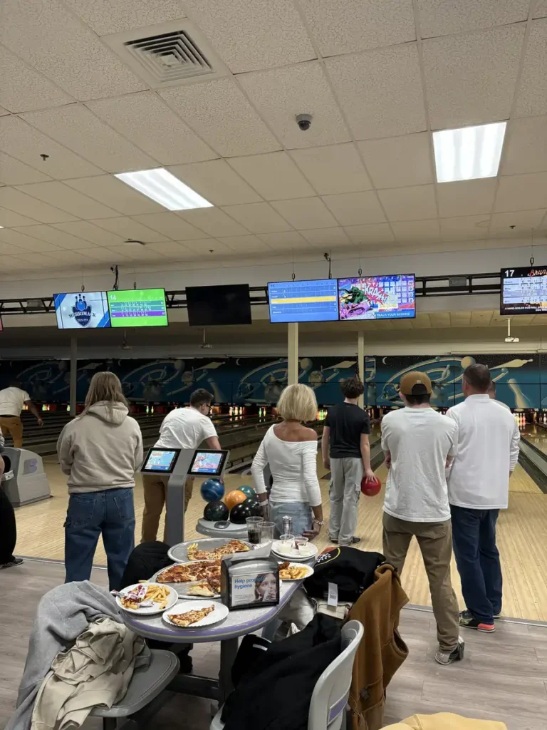 Group mingling between lanes at the Nashoba Springs bowling outing