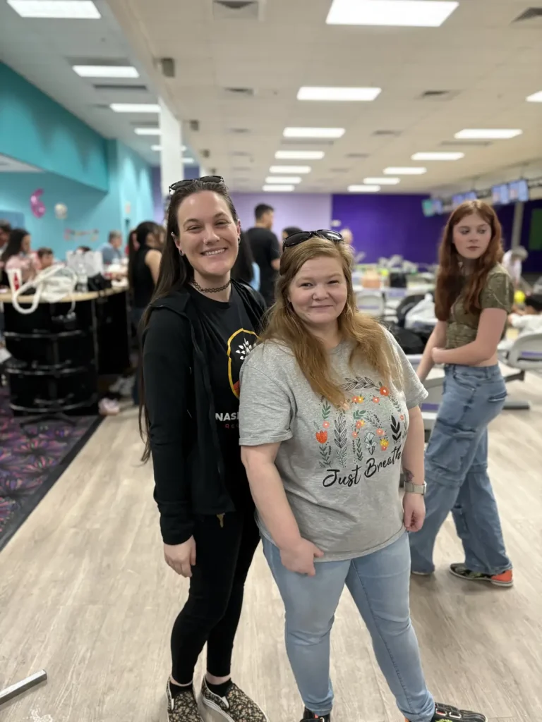 Two women smiling together at the Nashoba Springs bowling outing