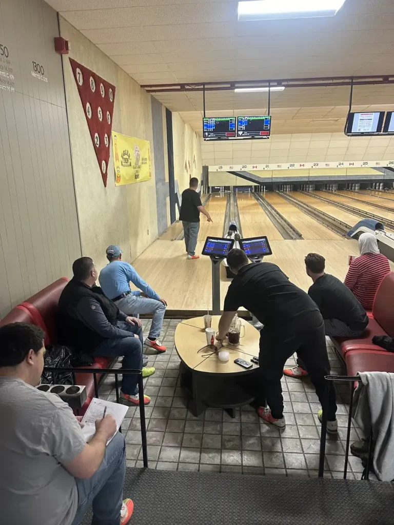 Guests bowling and watching from lounge seating at a Nashoba Springs bowling outing