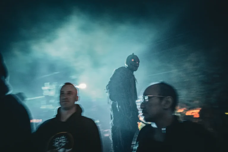 Masked performer among guests in fog at Fright Kingdom