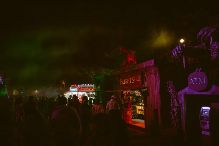 Haunted attraction storefronts lit up at night at Fright Kingdom
