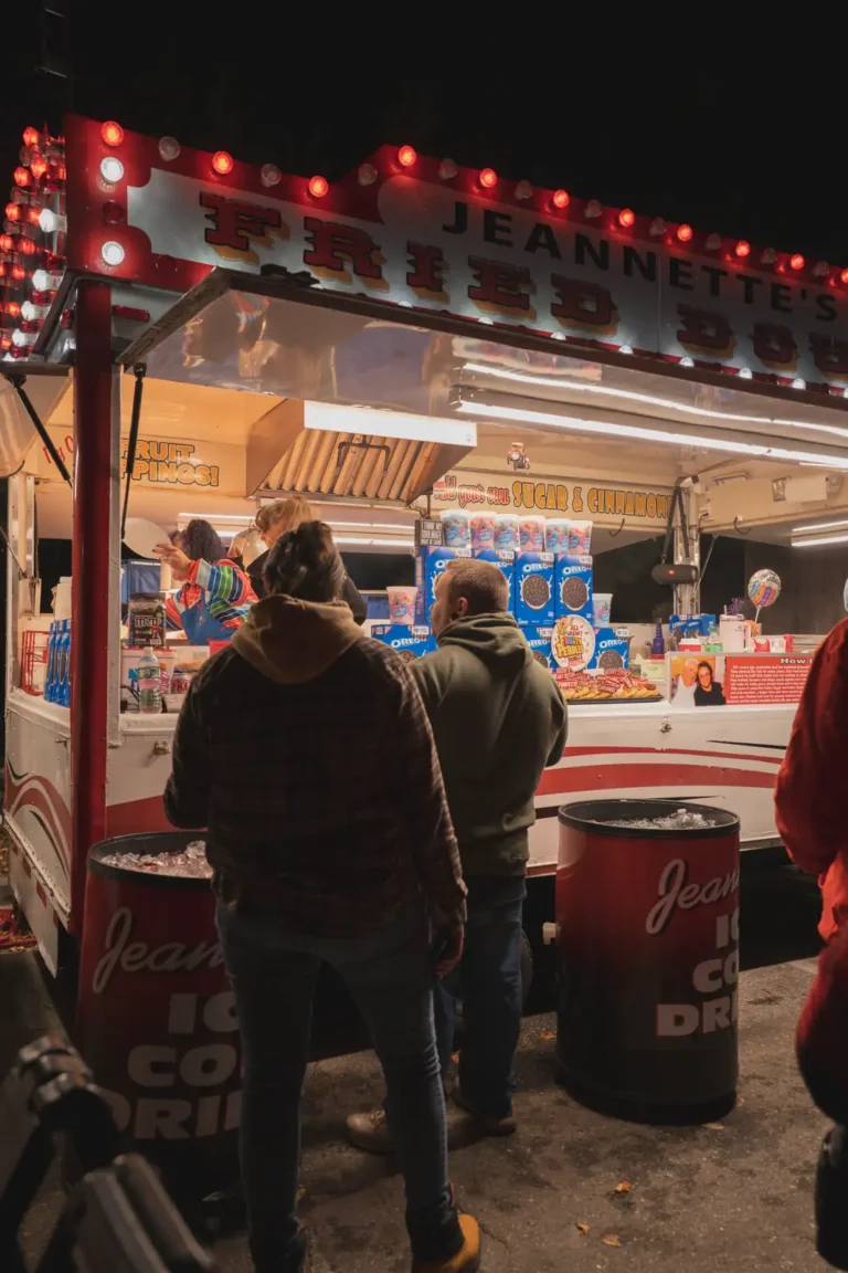Guest ordering at a lit food stand at Fright Kingdom