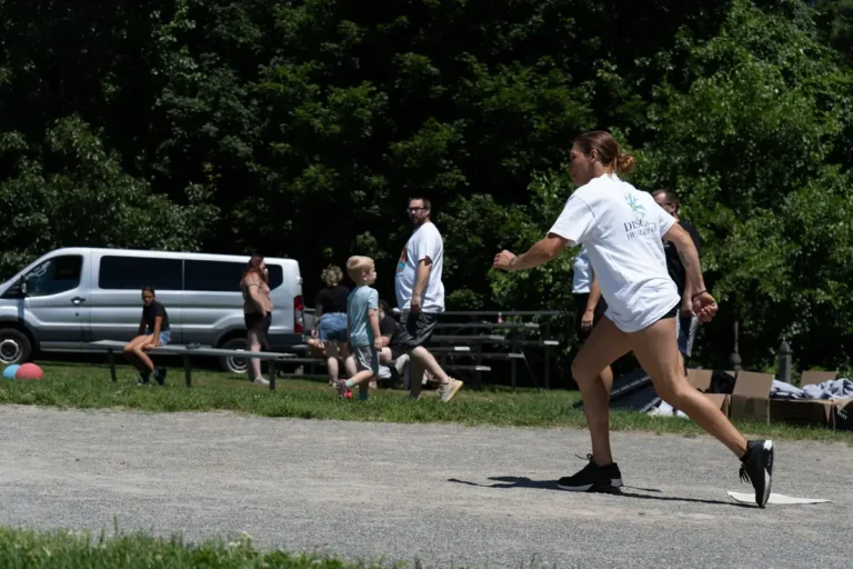 Woman running to kick at the Nashoba Springs kickball outing