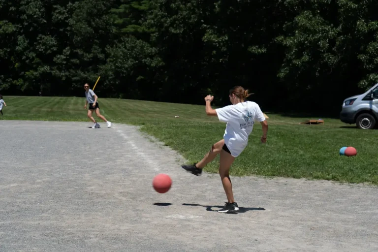 Woman kicking the ball toward the outfield at the Nashoba Springs kickball outing